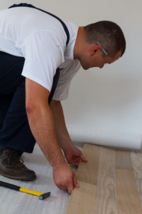 A commercial flooring contractor installs new flooring, focusing on precision and detail.