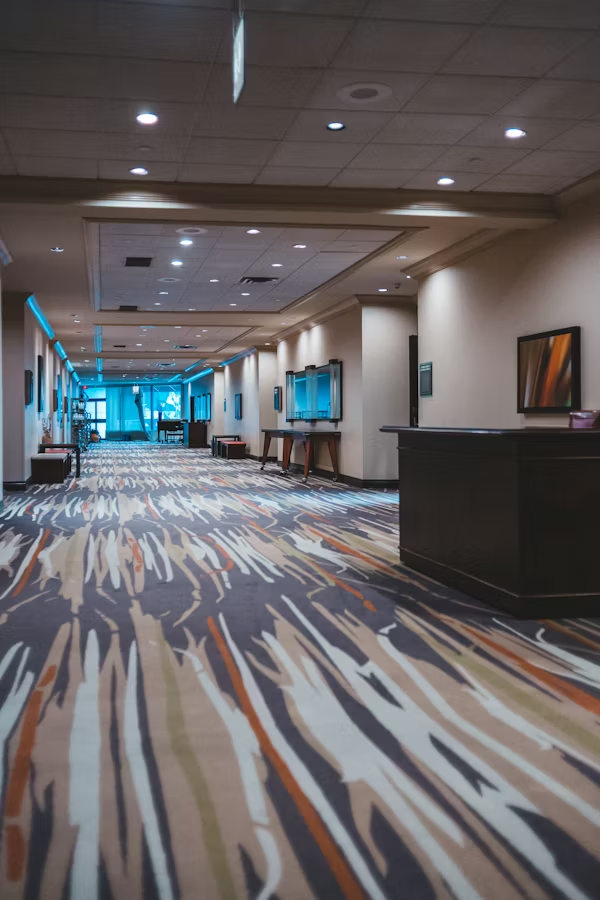 Hotel lobby featuring noise-reducing carpet tiles and reception desk.
